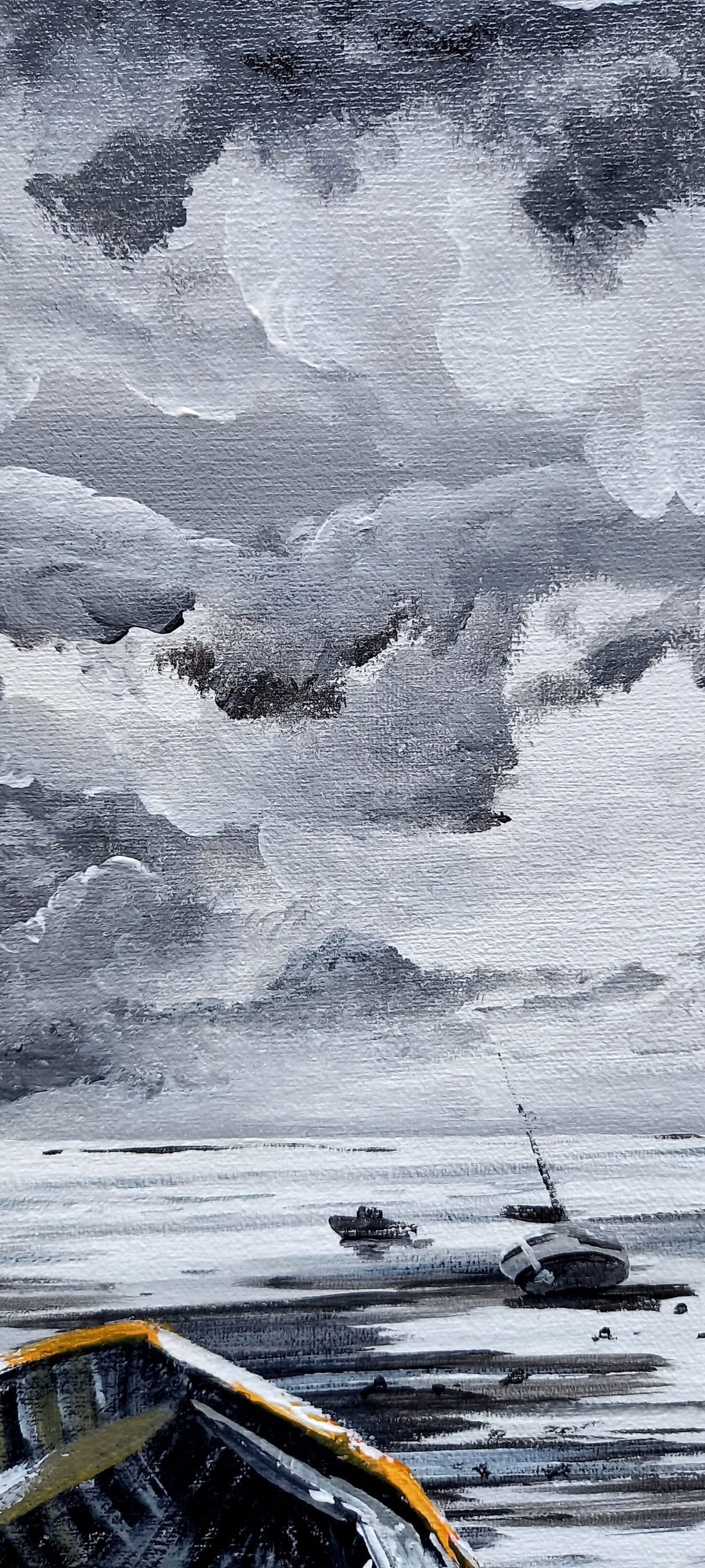 petits bateaux au loin posés sur le sable ciel nuageux